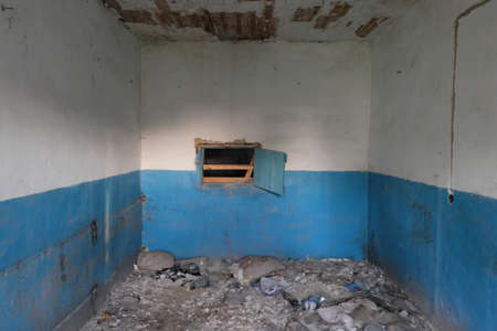 Chernihiv region, Ukraine, May 23, 2019. A small window inside an abandoned room. Garbage on the floor of an abandoned house.のeditorial素材