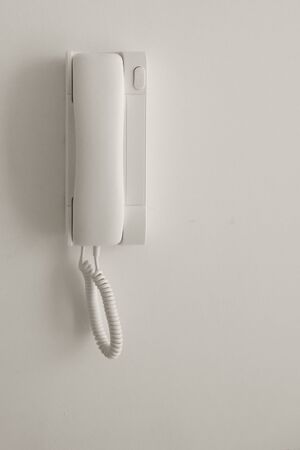 White telephone on a white wall. Copyspace.