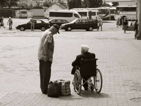 Chernihiv, Ukraine, June 7, 2019. A train station employee communicates with an elderly man in a...