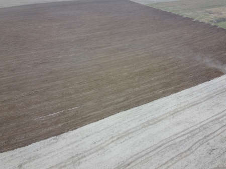 Partially plowed agricultural field, aerial view. Agricultural field, arable land. Background