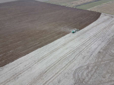 Tractor plows a field, aerial view. Agricultural landscape.