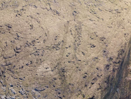 Traces of construction equipment on the soil, aerial view. Lifeless land, wasteland.