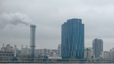 Kyiv, Ukraine, February 25, 2020. DTEK modern office on a cloudy day. The pipes throw smoke into the...