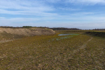 The exposed bottom of a dry pond. A shallow water body.