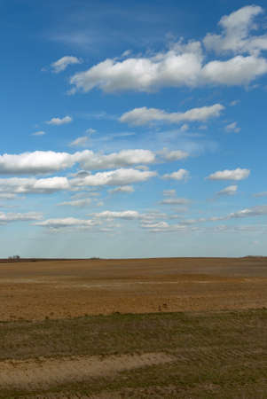 Beautiful cloudy sky over farmland. Spring landscape.