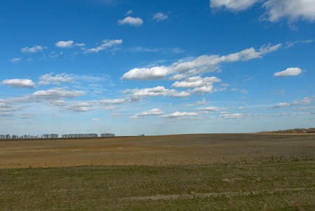 Beautiful cloudy sky over farmland. Spring landscape.