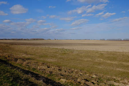 Beautiful cloudy sky over farmland. Spring landscape.