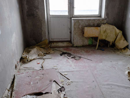 The espalier are loose from the walls. Heaps of rubbish on the floor of an abandoned apartment. Dirt...