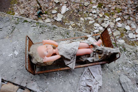 Creepy doll on a toy bed. Abandoned toys in a kindergarten in Pripyat.の写真素材