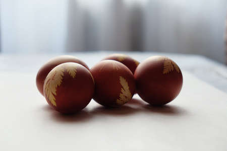 Painted Easter eggs on a white background. Floral pattern on a red eggshell. Festive food.の写真素材