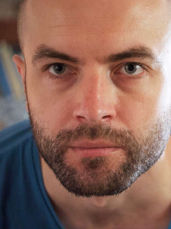 The gaze of a white man. Portrait, close-up. A man with a stubble on his face.