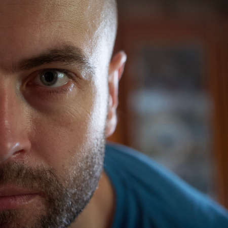 The gaze of a white man. Portrait, close-up. A man with a stubble on his face.