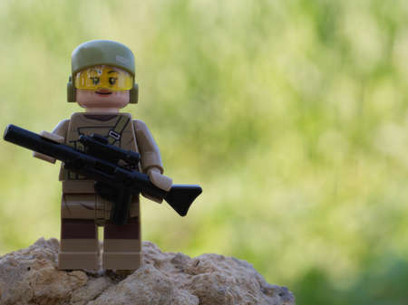 Chernihiv, Ukraine, July 13, 2021. A girl soldier armed with a rifle. A small plastic toy....