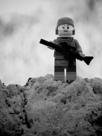 Chernihiv, Ukraine, July 13, 2021. A girl soldier armed with a rifle. A small plastic toy....