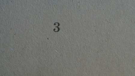 The number 3 printed on a piece of paper. Paper texture.