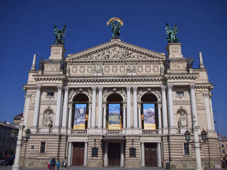 Lviv, Ukraine, March 25, 2022. The Solomiya Krushelnytska Lviv State Academic Theater of Opera and Ballet on a sunny day. Posters on the facade of the theatre. people on the street.のeditorial素材