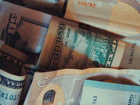 Cash banknotes dollars and euros are mixed up, a close-up shot.の写真素材