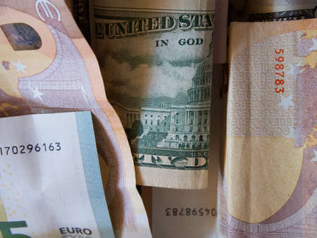 Cash banknotes dollars and euros are mixed up, a close-up shot.