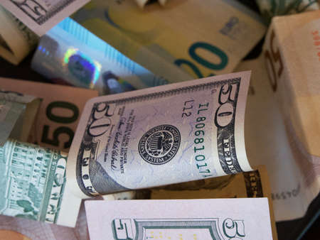 Cash banknotes dollars and euros are mixed up, a close-up shot.の写真素材