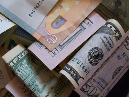 Cash banknotes dollars and euros are mixed up, a close-up shot.の写真素材