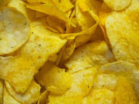 Spiced potato chips, a close-up shot. Fried potatoes.