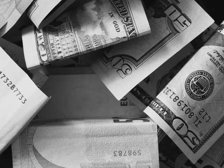Cash banknotes dollars and euros are mixed up, a close-up shot. Black and white image.の写真素材