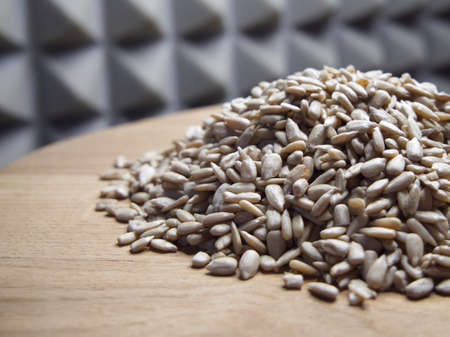 A pile of peeled sunflower seeds on a wooden surface, close-upの写真素材