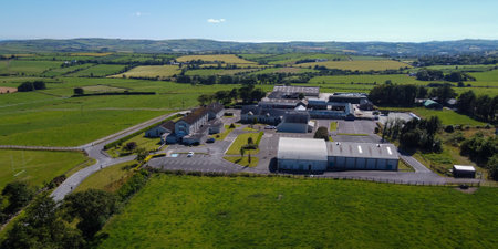 West Cork, Ireland, July 9, 2022. Clonakilty Agricultural College among green fields on a sunny summer day, buildings on green grass field, top view.のeditorial素材