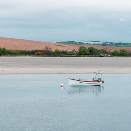 A motor boat. Calm water surface. Picturesque hills on the shore of the bay. The sandy shore of the...