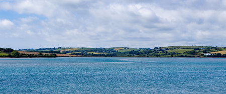 There are a lot of cumulus clouds in the sky over the sea coast on a summer day. Seaside Irish...