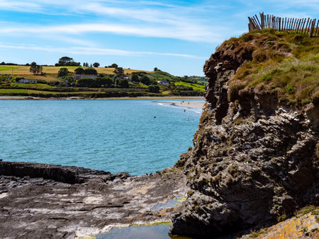 A sheer stone cliff on the Atlantic Ocean in Ireland on a sunny summer day. Irish seaside landscape, clear blue sky, rock formation.の写真素材