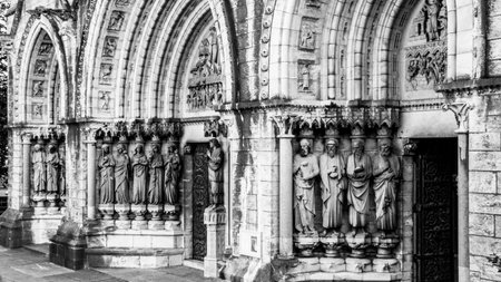 Details of the facade of Saint Fin Barre's Cathedral in Cork, Ireland. Sculptures of religious figures at the entrance to the church. monochrome.の写真素材