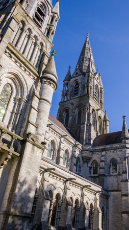 The tall Gothic spire of an Anglican church in Cork, Ireland. Neo-Gothic religious architecture. Cathedral Church of St Fin Barre, Cork - One of Ireland's Iconic Buildings.の写真素材