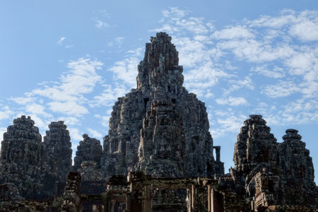 Majestic stone towers of the medieval Khmer Bayon Temple in Cambodia under a clear blue sky.の写真素材