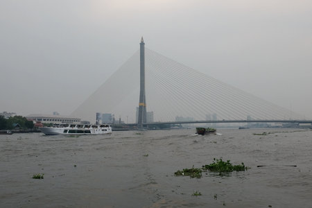 Bangkok, Thailand, December 28, 2018. In Bangkok, the Rama VIII Bridge, featuring a single pylon, extends over the Chao Phraya River against a gloomy backdrop.のeditorial素材