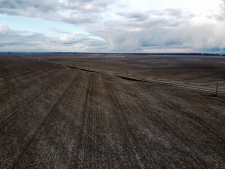 Dirt road among cultivated fields, aerial view. Agricultural field, arable land.