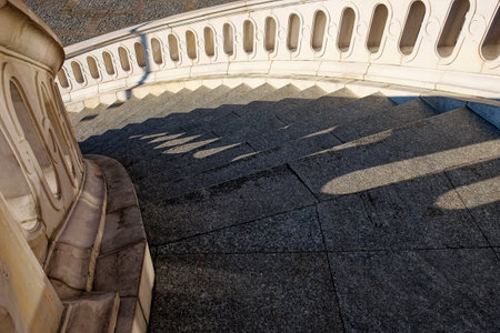 Ancient stone twisted staircase leading down. Large staircase with beautiful stone railings.の写真素材