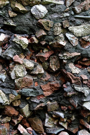 A close-up image of a stone wall with different colored rocks and stones.の写真素材