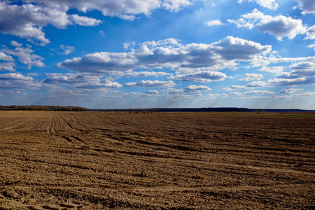 A barren landscape with plowed earth and cloudy skies.の写真素材