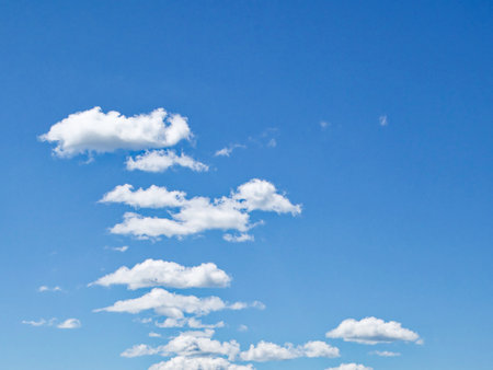 A clear sky with scattered white clouds.の写真素材