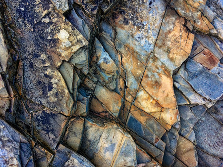 Weathered rocks with intricate patterns and a mix of dark and light colors are tightly packed.の写真素材