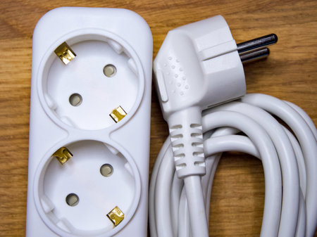 Electrical plug and socket on wood, showing a concept of power supply and energy.の写真素材