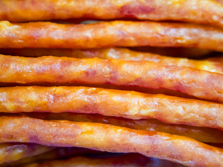 A close up of a row of meat sticks. The sticks are brown and have a slightly crispy texture. Concept of indulgence and satisfaction, as the meat sticks are likely to be a tasty snack or appetizer.の写真素材