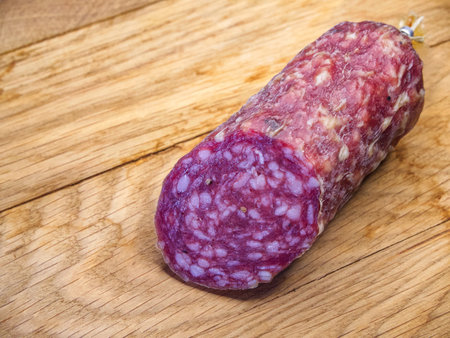 The salami's rich color and visible fat content indicate a high-quality product.の写真素材