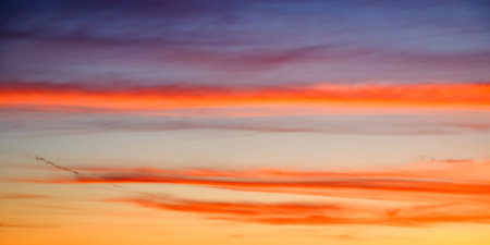 A serene sunset painting the sky with hues of orange, blue, and purple, evoking a sense of calm. Ideal for relaxation content.の写真素材