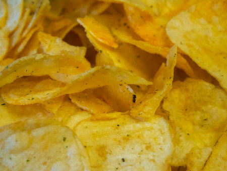 Herbed Potato Chips. Potato chips with green herb seasoning, suggesting flavor.の写真素材