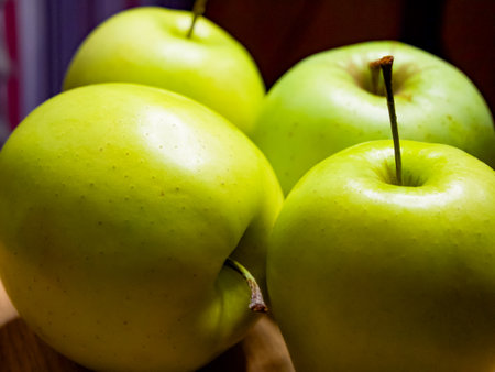 A quartet of shiny green apples, closely grouped. This image suggests natural, wholesome food choices for consumers.の写真素材