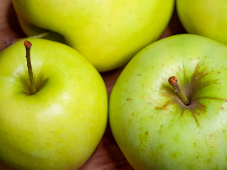 Brightly lit green apples, suggesting health and vitality, likely used in dietary content.の写真素材