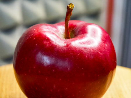 Moist surface of ripe red apple against subdued backdrop.の写真素材