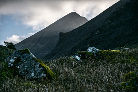 The photograph captures a mountainous landscape. A large mountain forms the backdrop. The foreground...